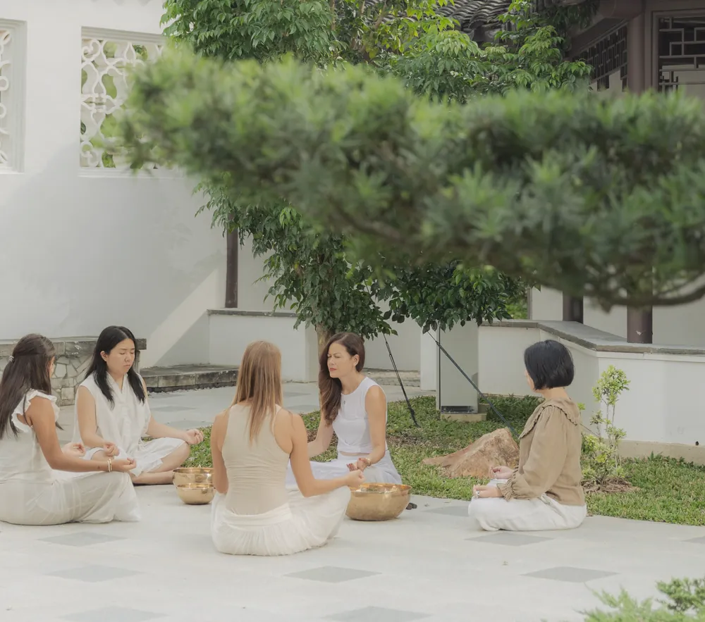 Women sitting together in a circle in a quiet garden courtyard